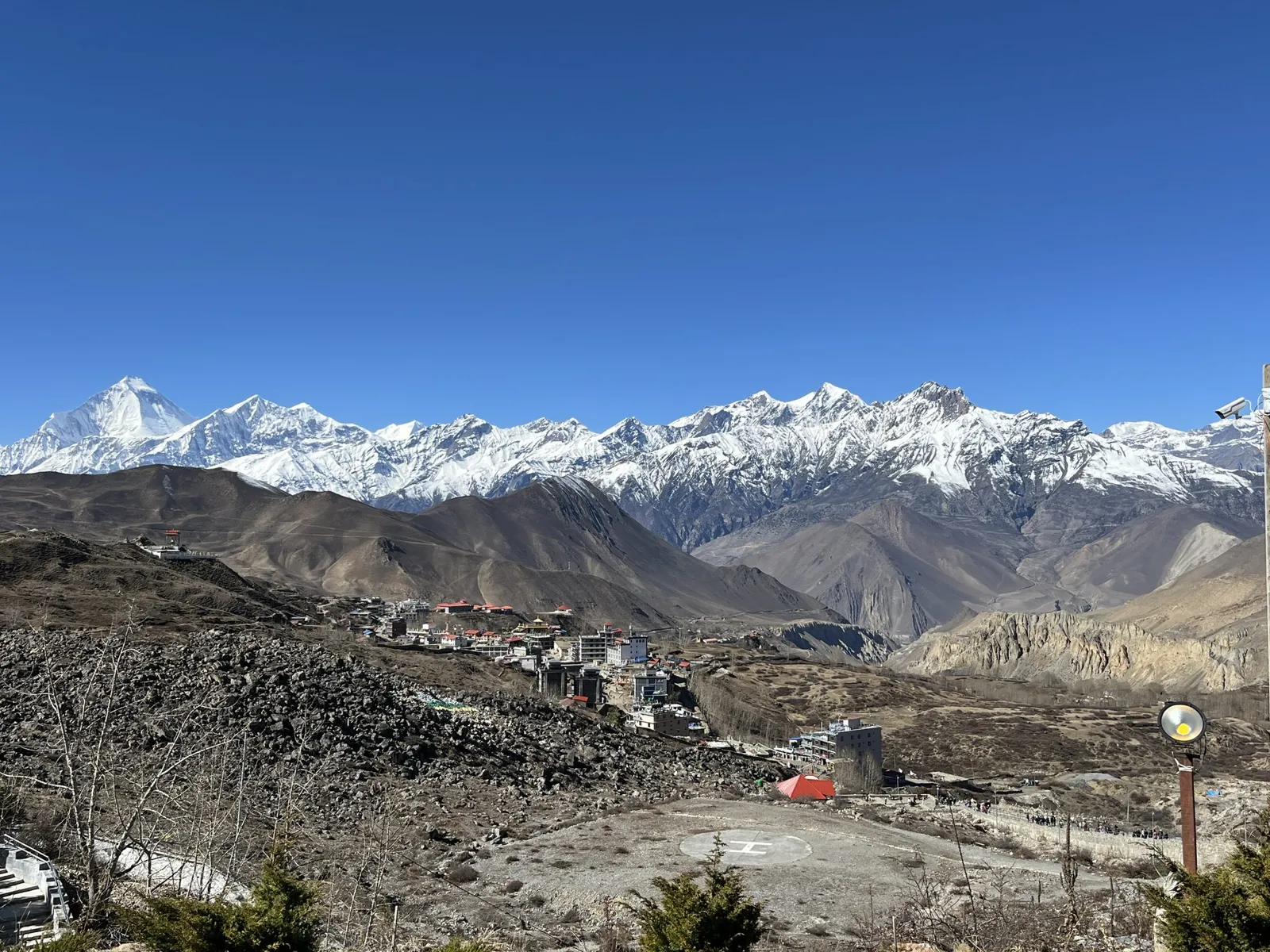 A high-altitude village in Mustang, Nepal, below a ridge of snow-covered Himalayan peaks